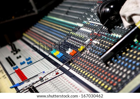 Modern music mixer in audio studio headquarters, dj at stand mixing songs