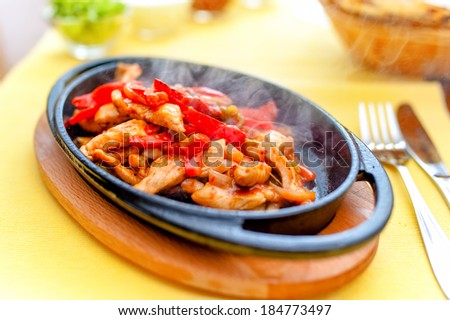 chicken fajita smoking hot served on iron plate and fresh vegetables