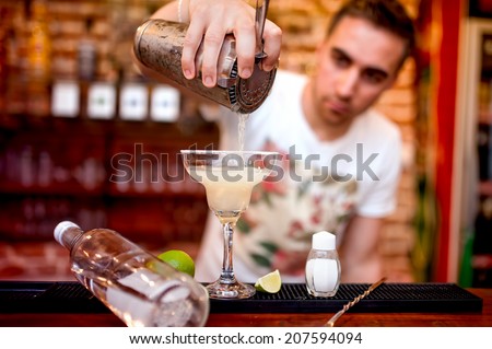 barman pouring a margarita alcoholic cocktail served in casino and bar