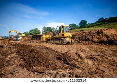 industrial machinery at working construction building site. Excavator, dumper truck and bulldozer working on ground