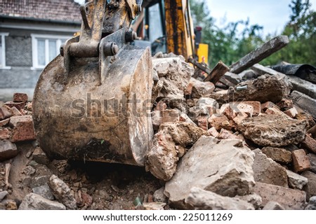 industrial hydraulic backhoe bulldozer loading demolition debris, stone and concrete for recycling