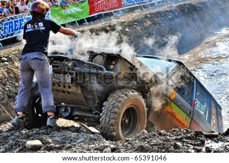 CLUJ-NAPOCA, ROMANIA - SEPT. 26: - The Copilot of an off-road crew tries to recover and repair their damaged car on Sept. 26, 2009 at Ursus Free Track Competition in Cluj Napoca, Romania