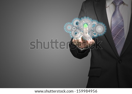 Businessman touch cloud shape filled with gears icon in space in gray background