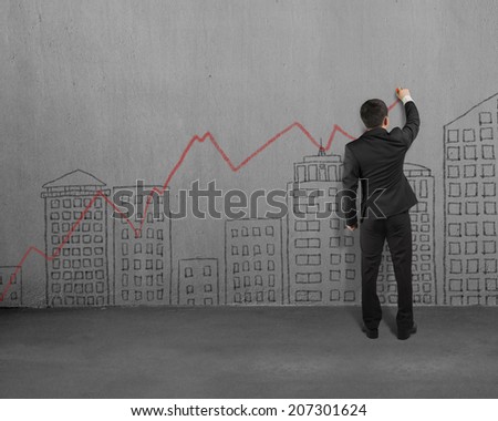 Businessman doodles on concrete wall