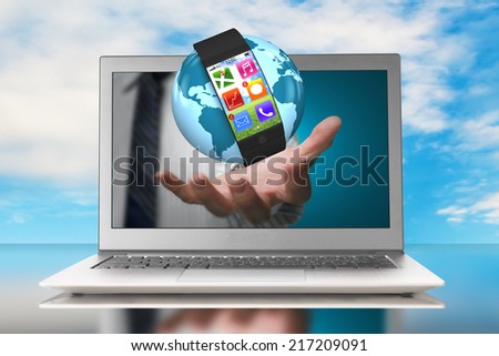 smartwatch and globe in hand through laptop with nature sky
