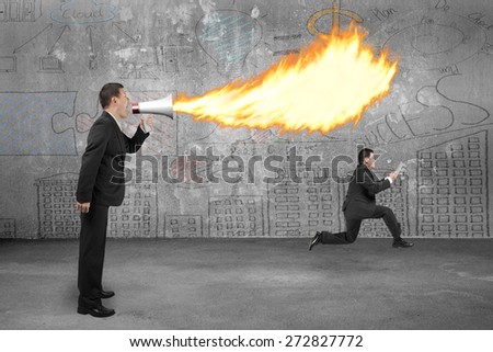 Angry boss using megaphone yelling to employee and spitting fire with business doodles concrete wall background