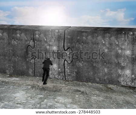 Man pushing huge puzzle door of concrete wall with nature sky sun background