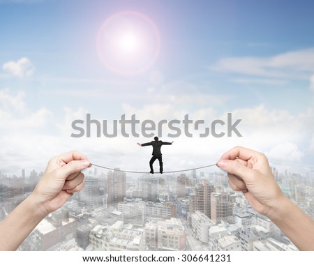 Businessman balancing on tightrope with woman two hands holding two sides, on sunny sky cityscape background.