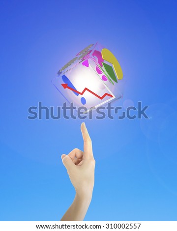 Human index finger pointing at illuminated transparent box of business graphs, on blue background.