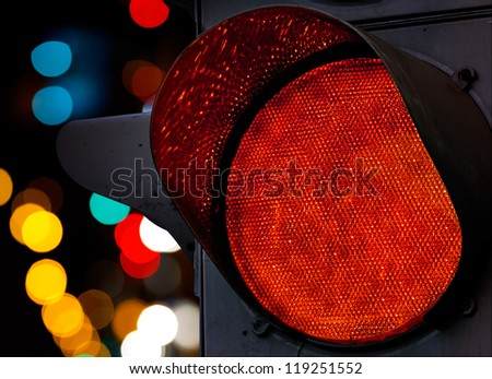 Red traffic light with colorful unfocused lights on a background