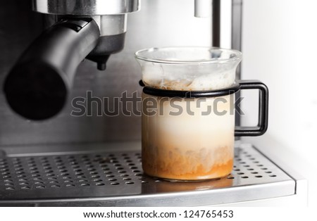 Modern glass of black coffee with milk in espresso machine