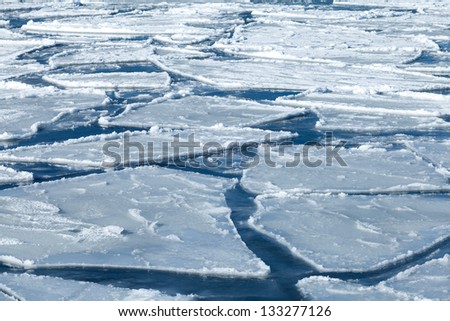 Winter nature background with blocks of ice on frozen blue Sea