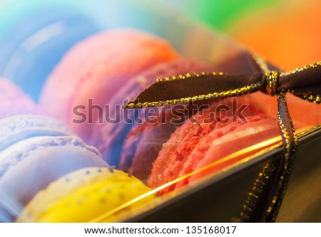 Macro with colorful macaroons in the gift box with tape. Macro photo with shallow depth of field