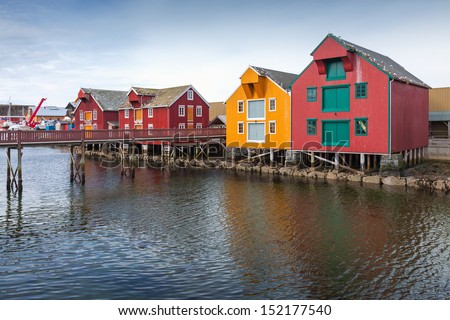 Red and yellow wooden houses in coastal Norwegian fishing village. Rorvik, Norway
