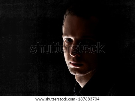 Closeup portrait of young Caucasian man in the dark