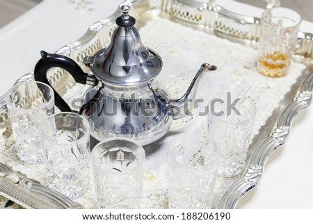 Moroccan tea theme. Metal teapot with glasses