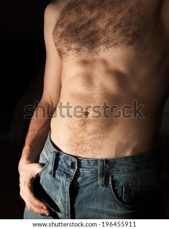 Flat sporty male belly. Close-up photo on dark background