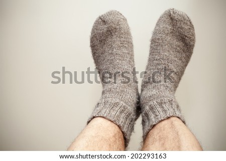 Closeup photo of male feet with gray woolen socks