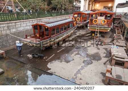 Hangzhou, China - December 5, 2014: Traditional Chinese wooden recreation boats under renovation in the shipyard. West Lake coast. Famous park in Hangzhou city, China