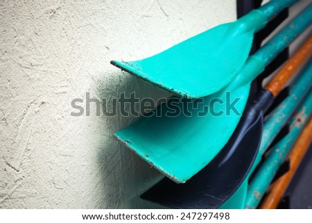 Group of paddles mounted on gray rural wall
