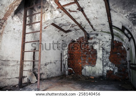 Old empty abandoned bunker interior with white walls and rusted constructions