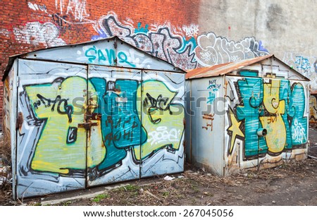 Saint-Petersburg, Russia - April 3, 2015: Two old rusted garages with colorful grungy graffiti. Vasilievsky island, Central old part of St. Petersburg city