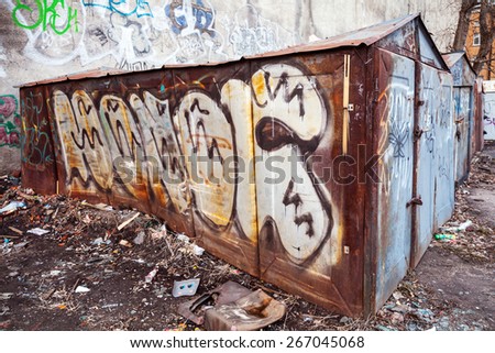 Saint-Petersburg, Russia - April 3, 2015: Old rusted garage with grungy graffiti and trash. Vasilievsky island, Central old part of St. Petersburg city