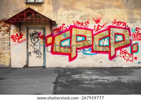 Saint-Petersburg, Russia - April 3, 2015: Graffiti fragment with text on the yellow wall. Vasilievsky island, Central old part of St. Petersburg city