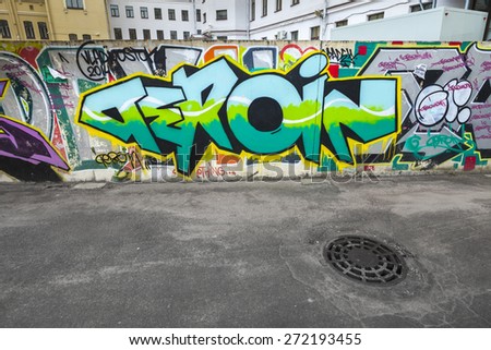 Saint-Petersburg, Russia - April 7, 2015: Colorful chaotic graffiti text on old concrete fence