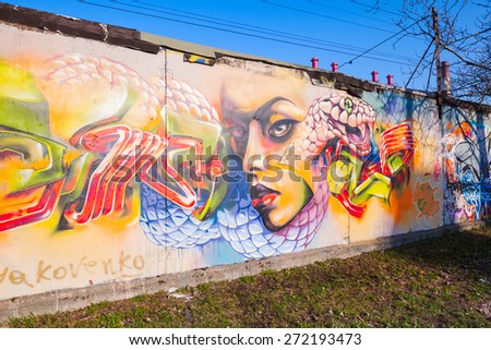 Saint-Petersburg, Russia - April 6, 2015: Colorful graffiti with girl portrait over old gray concrete garage walls