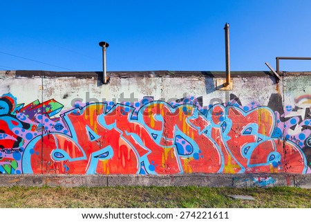 Saint-Petersburg, Russia - April 6, 2015: Colorful abstract graffiti painted on old gray concrete garage walls