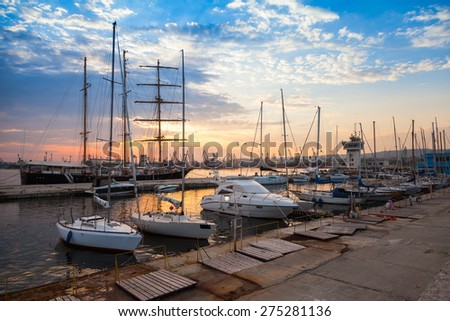 Sailing ships and yachts stand moored in Varna port at the sunset. Black Sea coast, Bulgaria