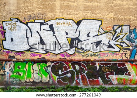 Saint-Petersburg, Russia - May 6, 2015: Abandoned urban courtyard with colorful abstract graffiti text patterns on old damaged wall. Vasilievsky island, St. Petersburg