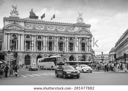 Paris, France - August 09, 2014: Palais Garnier, old Opera house in Paris with walkink people and cars on the street, monochrome photo