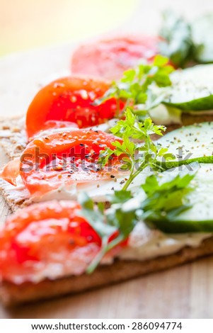 Healthy food. Bright breakfast sandwiches. Finnish rye crisp bread, soft cheese, cucumber, tomato, parsley and black pepper