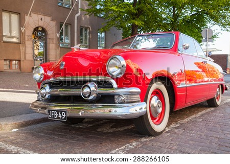 Helsinki, Finland - June 13, 2015: Old red Ford Custom Deluxe Tudor car is parked on the roadside. 1951 year modification with convertible roof, closeup photo