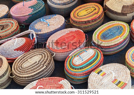 Colorful African wicker baskets stand on a counter in marketplace