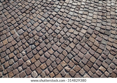 Brown granite cobblestone road pavement with round pattern. Background photo texture