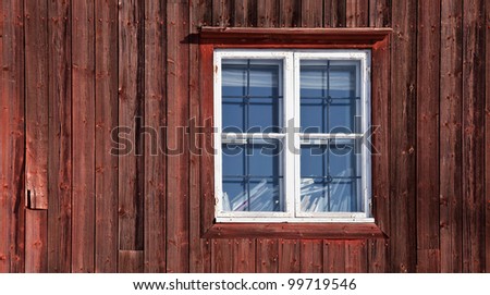 Texture of a window on the old red wooden wall. Traditional Scandinavian house
