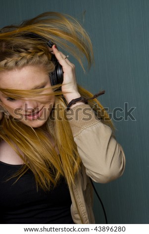 Beautiful Young Woman listening to music and dancing