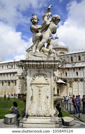 PISA, ITALY - JUNE 11: fountain sculpture and tourists round the Unesco World Heritage site Piazza dei Miracoli with Dome on June 11, 2012 in Pisa, Italy