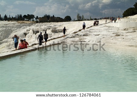 PAMUKKALE, TURKEY - APRIL 09: Unidentified tourists in the World Heritage site, a  place of interest contains travertines terraces of carbonate minerals, April 09, 2009 in Pamukkale, Turkey