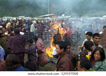 JAKAR, BHUTAN - SEPTEMBER 26: unidentified people running through an open fire at the yearly fire and smoke ceremony to cleans of sin in Thangbi Lakhang on September 26, 2007 in Jakar, Bhutan
