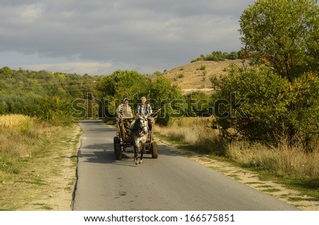 RILA, BULGARIA - SEPTEMBER 29: Unidentified friendly looking couple of peasants on horse cart in Rila valley - a traditional mode of transport in rural areas, on September 29, 2013 in Rila, Bulgaria