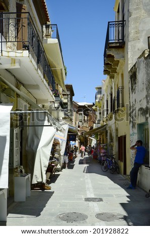 RETHYMNO, GREECE - MAY 24: Crowd of unidentified people in narrow street with shops, restaurant, and homes with Turkish balcony in the city in Crete, on May 24, 2014 in Rethymno, Greece