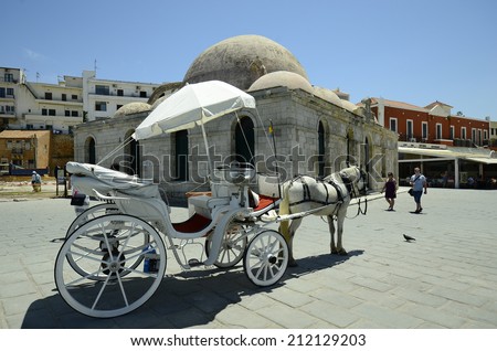 CHANIA, GREECE - MAY 27: Unidentified people and horse drawn coach in front of the Janissaries mosque aka Hassan Pascha mosque in the medieval village in Crete, on May 27, 2014, in Chania, Greece