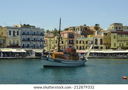 CHANIA, GREECE - MAY 27: Unidentified people, excursion boat and different restaurants and hotels on the harbor of the medieval village in Crete, on May 27, 2014, in Chania, Greece