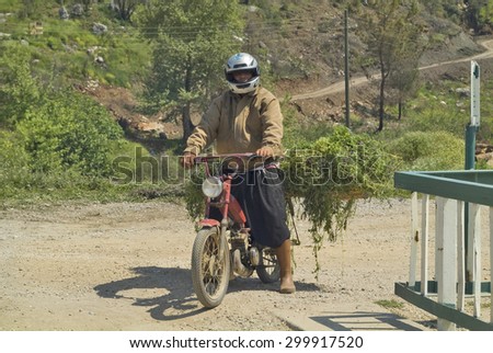 MANAVGAT, TURKEY - APRIL 12: Unidentified man on bike laden with fodder in the suburb of the village, on April 12, 2009 in Manavgat, Turkey