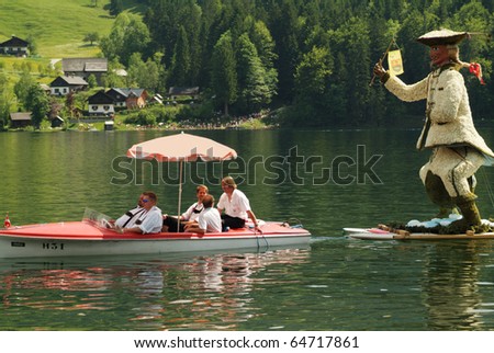 BAD AUSSEE, AUSTRIA - MAY 30: unidentified people in a boat and figure of Baron Muenchhausen made with flowers on Grundlsee-Lake by Narcissus Festival on May 30, 2005 in Bad Aussee in Styria, Austria