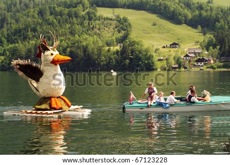 BAD AUSSEE, AUSTRIA - MAY 30: unidentified actors and spectators with flower decorated figures by yearly Festival of Narcissus on the Grundlsee-Lake on May 30, 2005 on Bad Aussee in Styria, Austria